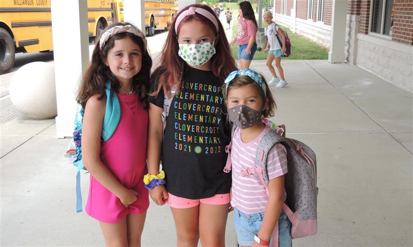 Three students smile